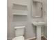 Cozy bathroom with a pedestal sink, toilet, and shelves, offering a simple and functional space at 22944 E Via Del Oro --, Queen Creek, AZ 85142