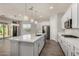 Spacious kitchen boasts a large island, stainless appliances, quartz counters, stylish pendant lighting, and access to the backyard at 22944 E Via Del Oro --, Queen Creek, AZ 85142