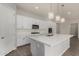 Bright kitchen features white cabinetry, stainless appliances, quartz countertops, stylish backsplash, and elegant pendant lighting at 22944 E Via Del Oro --, Queen Creek, AZ 85142