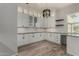 Large pantry with white cabinets, granite countertops, under cabinet lighting, and wood flooring at 22944 E Via Del Oro --, Queen Creek, AZ 85142