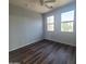 Bedroom featuring modern wood-look floors, two windows, and light grey walls and ceiling fan at 2323 E Huntington Dr, Phoenix, AZ 85040