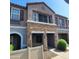 Attractive townhome facade showcasing stone detailing, covered porch, and lush greenery at 2323 E Huntington Dr, Phoenix, AZ 85040