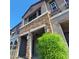 Townhome's stylish exterior with stone facade, covered entrance, and vibrant landscaping at 2323 E Huntington Dr, Phoenix, AZ 85040