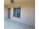 Exterior shot of the front entrance with neutral stucco and a window with brick trim at 2323 E Huntington Dr, Phoenix, AZ 85040