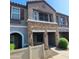 Inviting townhome exterior featuring stone accents, covered entry, and well-manicured shrubbery at 2323 E Huntington Dr, Phoenix, AZ 85040