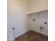 A compact, well-lit laundry room with shelf, tiled floor, and connections for washer and dryer at 2323 E Huntington Dr, Phoenix, AZ 85040