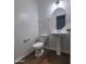 Bright powder room featuring tile floors, toilet, and a pedestal sink with a decorative mirror at 2323 E Huntington Dr, Phoenix, AZ 85040