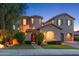 Elegant two-story home featuring a circular tower, arched entryway, dark shutters and a manicured lawn at 26036 N 85Th Dr, Peoria, AZ 85383