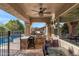 Covered outdoor kitchen featuring a built-in grill, bar seating, and a view of the pool at 26036 N 85Th Dr, Peoria, AZ 85383