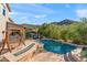 Beautiful backyard pool with surrounding desert landscaping and a relaxing porch swing at 26036 N 85Th Dr, Peoria, AZ 85383