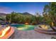 Inviting pool area with a spa, fire pit, and lush landscaping offering a serene and private outdoor space at 26036 N 85Th Dr, Peoria, AZ 85383