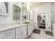 Bright bathroom featuring a double vanity with decorative mirrors and lighting with access to a walk-in closet at 2759 E Balsam Dr, Chandler, AZ 85286