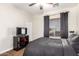 Cozy bedroom features neutral paint, a black comforter, tv, and a window with blinds at 2759 E Balsam Dr, Chandler, AZ 85286