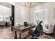 Comfortable home office with a rustic wooden desk, chandelier, and cushioned chair at 2759 E Balsam Dr, Chandler, AZ 85286