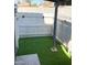 Small backyard featuring fresh artificial grass with an installed sprinkler system, privacy fencing, and string lights at 286 W Palomino Dr # 78, Chandler, AZ 85225