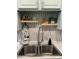 Close-up view of the kitchen sink area with decor, floating shelves, and stylish backsplash at 286 W Palomino Dr # 78, Chandler, AZ 85225