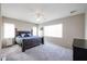 This is a bright bedroom with a large bed, two windows, neutral walls and gray carpet at 2934 W Peggy Dr, San Tan Valley, AZ 85144