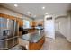 Functional kitchen boasts stainless steel appliances, wooden cabinets, tile flooring, and an island with countertop seating at 2934 W Peggy Dr, San Tan Valley, AZ 85144