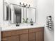 A stylish bathroom features a double vanity with quartz countertops, modern mirrors, and wood-style cabinets at 3008 S Saguaro Cir, Mesa, AZ 85202