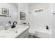 Bright bathroom featuring a vanity with a quartz countertop, a white tiled shower and bathtub at 3008 S Saguaro Cir, Mesa, AZ 85202