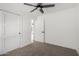 Bright bedroom with neutral carpet, ceiling fan, and white paneled doors at 3008 S Saguaro Cir, Mesa, AZ 85202