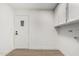 Laundry area with white cabinets, wood look flooring, and access door to outside at 3008 S Saguaro Cir, Mesa, AZ 85202