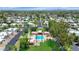 Aerial view of a desert community featuring red-roofed condos surrounding a sparkling pool and lush green landscaping at 34 E Boca Raton Rd, Phoenix, AZ 85022