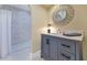 Stylish bathroom featuring a walk-in shower with tiled walls and a vanity with marble countertop and grey cabinets at 34 E Boca Raton Rd, Phoenix, AZ 85022