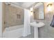 Bright bathroom features tiled walls, shower-tub combo with white shower curtain and pedestal sink with gold-trimmed mirror at 34 E Boca Raton Rd, Phoenix, AZ 85022