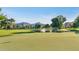 View of a lush golf course featuring a pond, mature trees, and a flag on the green on a sunny day at 34 E Boca Raton Rd, Phoenix, AZ 85022