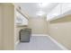 Laundry room features tiled floors, washer, dryer, and ample storage space with built-in cabinets and lighting at 34 E Boca Raton Rd, Phoenix, AZ 85022