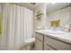 Well-lit bathroom featuring a shower with white curtain, white vanity, and stylish wall decor at 3600 N Hayden Rd # 2310, Scottsdale, AZ 85251
