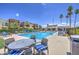 Large community pool with lounge chairs and palm trees under a sunny blue sky at 3600 N Hayden Rd # 2310, Scottsdale, AZ 85251