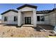 Exterior construction of home with a modern entrance featuring dark double doors at 37459 W Missouri Ave, Tonopah, AZ 85354