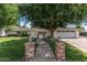 Charming home featuring a brick walkway, lush lawn, white picket fence, and large tree, with a two-car garage at 3817 E Highland Ave, Phoenix, AZ 85018
