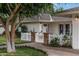 Inviting home exterior with white picket fence, brick accents, manicured lawn, and a charming entrance gate at 3817 E Highland Ave, Phoenix, AZ 85018