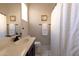 Bright bathroom featuring marble floors, dark cabinetry, and a shower with a decorative curtain at 4064 E Reins Rd, Gilbert, AZ 85297