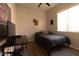 Cozy bedroom with hardwood floors, a bed with a dark quilt, and a black desk at 4064 E Reins Rd, Gilbert, AZ 85297