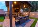 Custom outdoor kitchen with granite counters, built-in grill, TV, and wicker furniture at 4064 E Reins Rd, Gilbert, AZ 85297