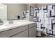 Well-lit bathroom features a modern sink and vanity with a stylish shower curtain at 40918 W Hillman Dr, Maricopa, AZ 85138