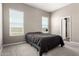 Bedroom with two windows, neutral walls, carpet flooring, and a minimal modern design at 40918 W Hillman Dr, Maricopa, AZ 85138