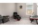 Cozy bedroom featuring a comfortable black leather chair, foot rest, and bright window at 40918 W Hillman Dr, Maricopa, AZ 85138