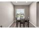 Dining area featuring a dark wood table, seating for four, and a view to the exterior at 40918 W Hillman Dr, Maricopa, AZ 85138