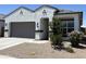 Inviting single-story home with stucco siding, a gray garage door, and drought-tolerant landscaping at 40918 W Hillman Dr, Maricopa, AZ 85138