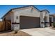 Exterior shot of a one-story home with a two-car garage and desert landscaping in the front yard at 40918 W Hillman Dr, Maricopa, AZ 85138
