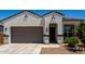 Beautiful front exterior featuring desert landscaping, two-car garage, and a covered entry at 40918 W Hillman Dr, Maricopa, AZ 85138