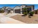 Home exterior featuring desert landscaping, a two-car garage, and a welcoming entrance at 40918 W Hillman Dr, Maricopa, AZ 85138