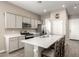 Modern kitchen featuring an island with seating, stainless steel appliances, and gray cabinetry at 40918 W Hillman Dr, Maricopa, AZ 85138