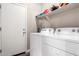 Functional laundry room with a new washer and dryer, plus shelving for storage at 40918 W Hillman Dr, Maricopa, AZ 85138
