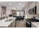 Kitchen and living room with modern stainless steel appliances and tile floors at 40918 W Hillman Dr, Maricopa, AZ 85138